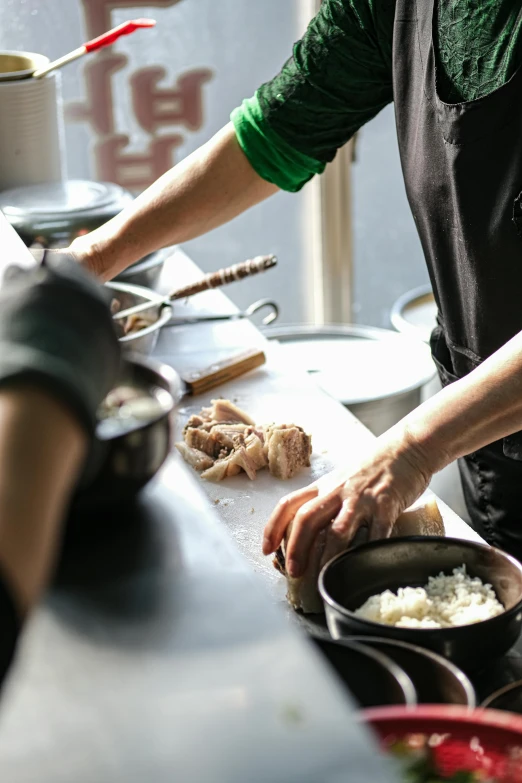 two chefs in a kitchen making sushi and rice