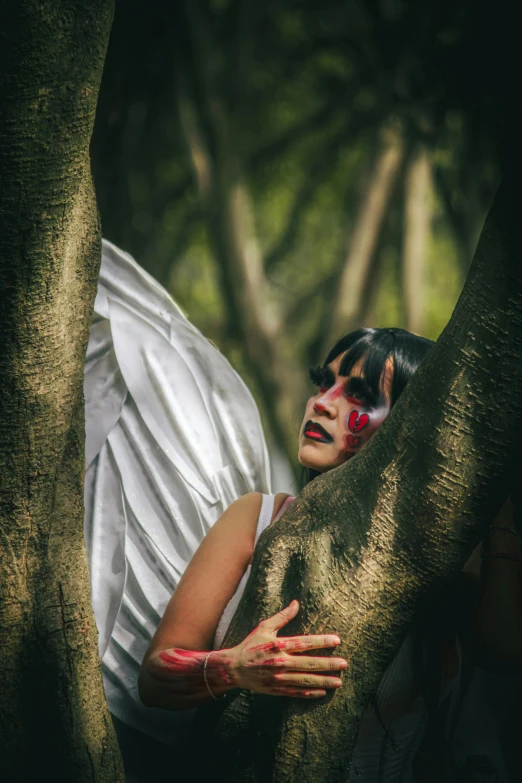 a woman with red painted face standing by a tree