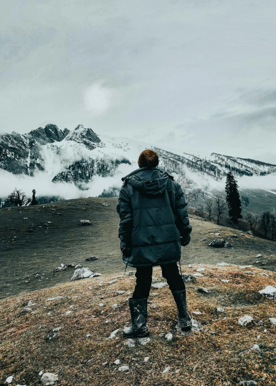 a person standing on top of a mountain with a ski board