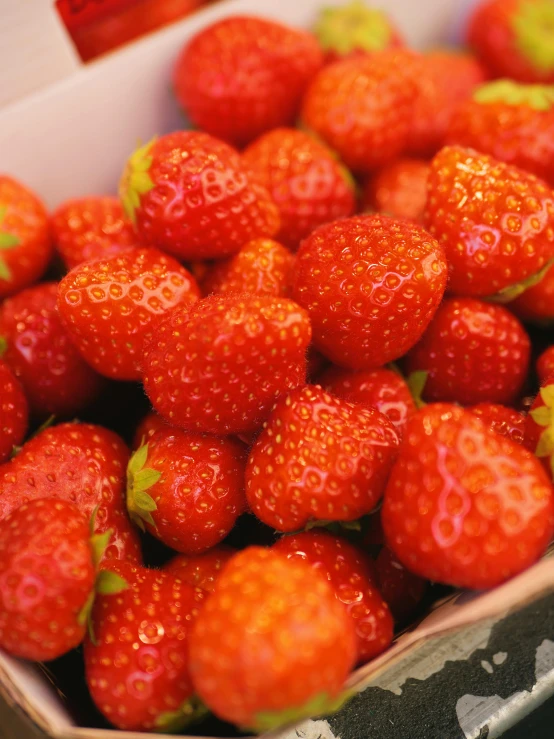 strawberries are stacked high in the box