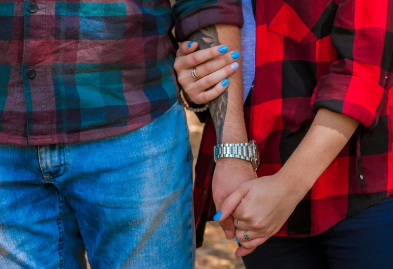 two people are holding hands while standing close to each other