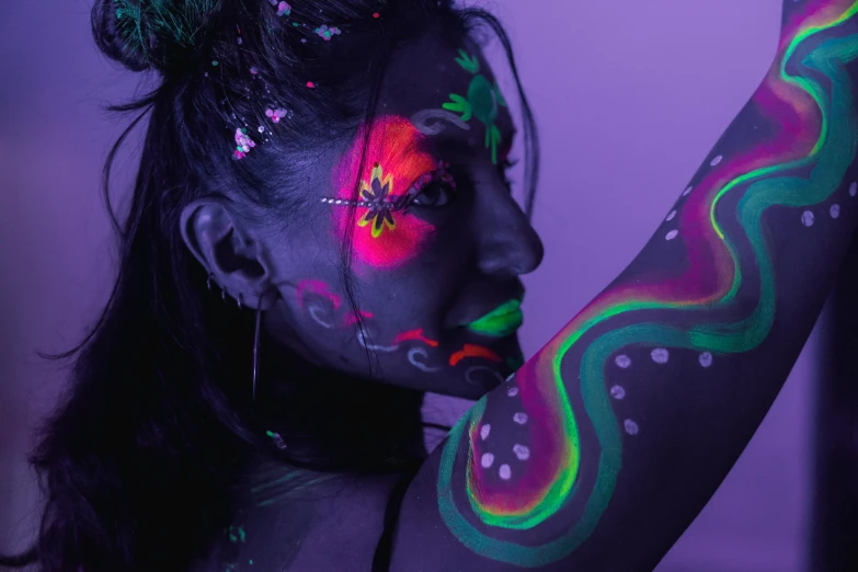 the young woman is covered in fluorescent colors