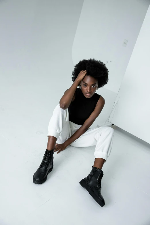 young black woman sitting on a floor in a white room