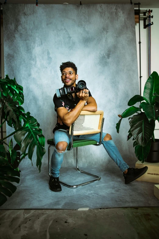 a man sitting on top of a chair holding a dog