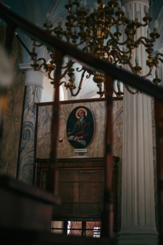 a picture of a priest sits in front of a column