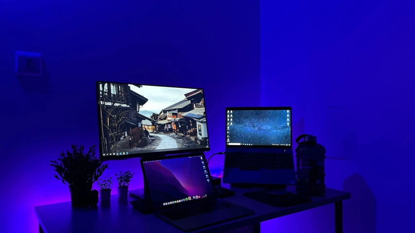 a desktop and laptop setup in a corner of a room