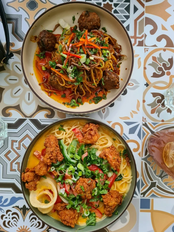 bowls filled with noodles, meat and vegetables with drinks