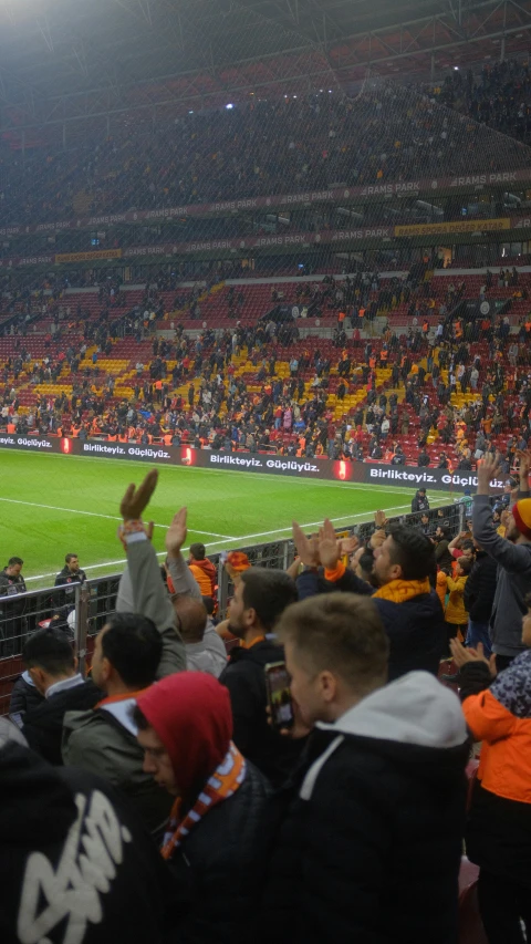 a crowd watching people play soccer on an empty field