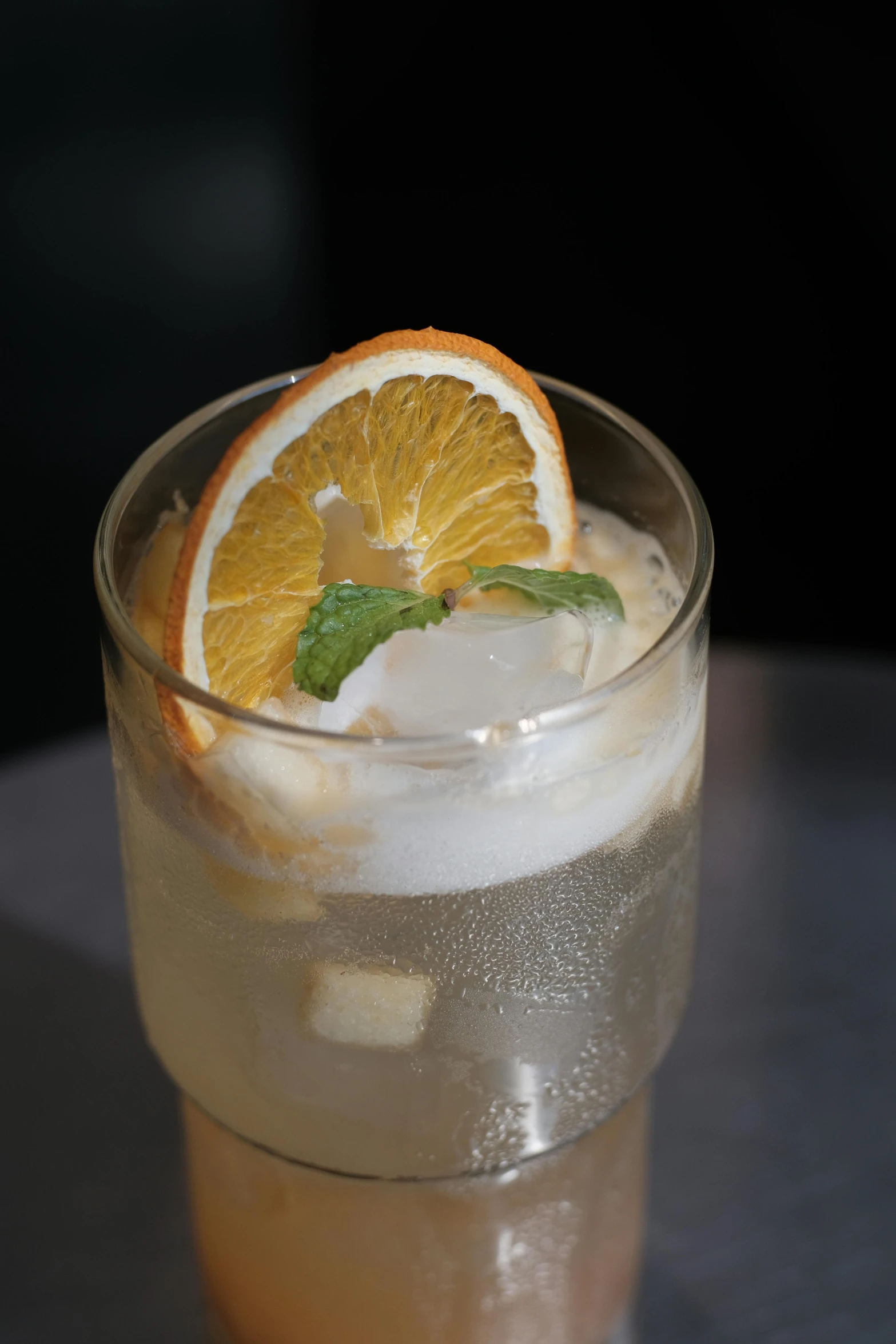 an orange slice sits on the rim of a glass