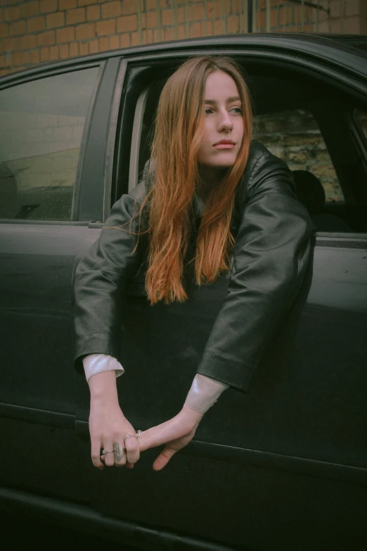 a young lady leaning out the back of a car