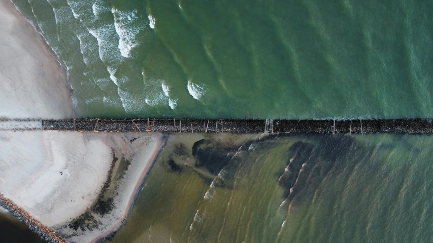 a pier stretches into the ocean from a view of land