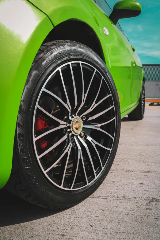 the front wheel of a bright green sports car