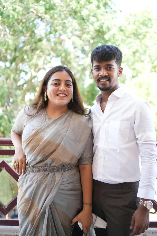 two people posing together wearing a sari