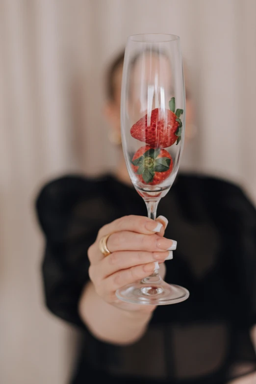 a person with a black shirt and celet holding a wine glass