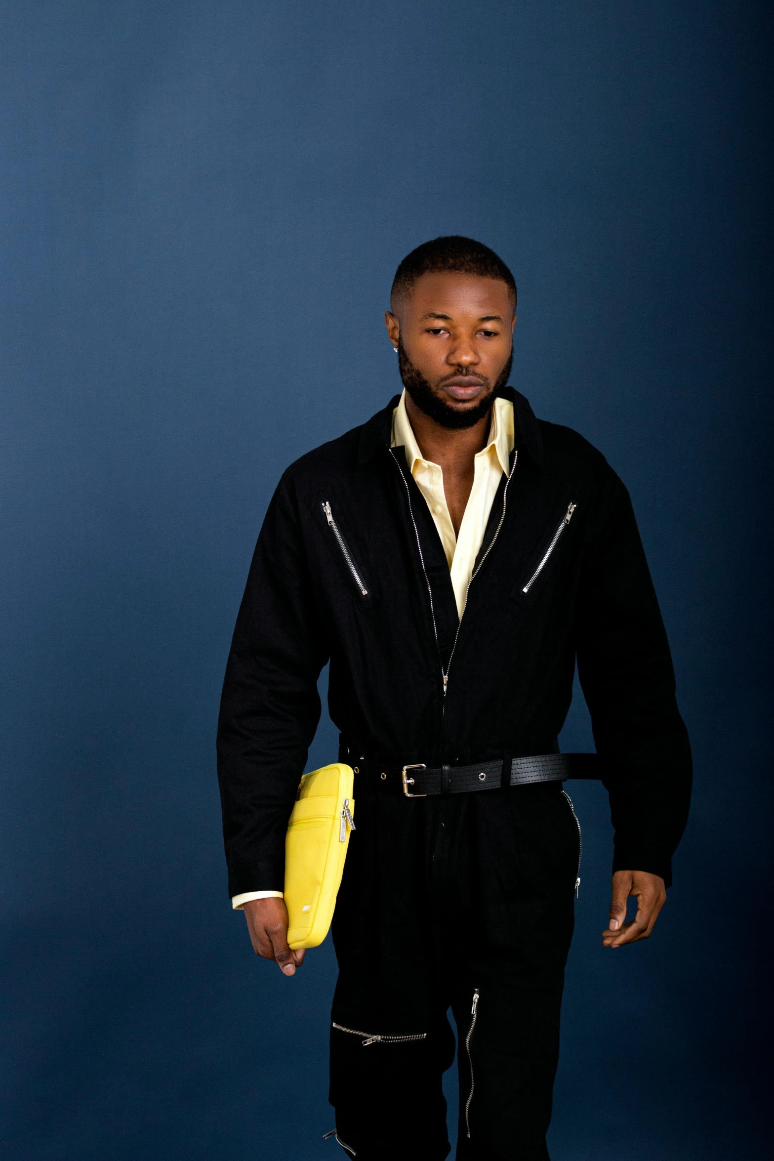 man wearing black clothing and holding yellow object