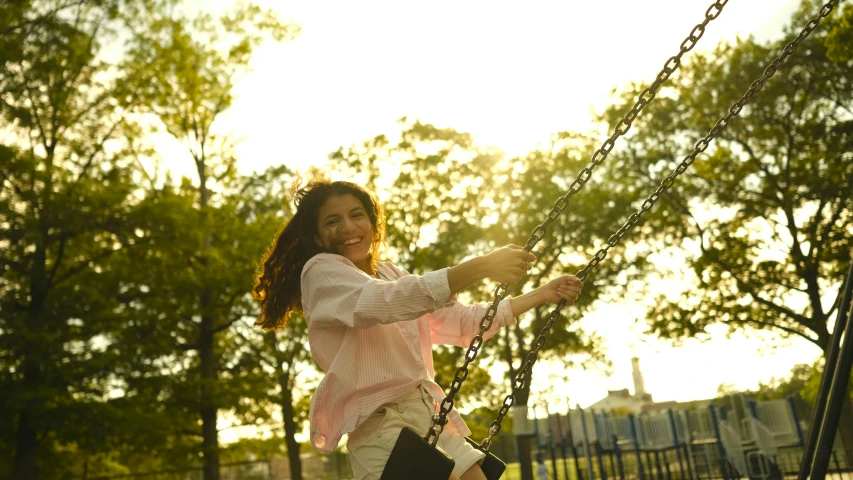 the girl is swinging on the playground equipment