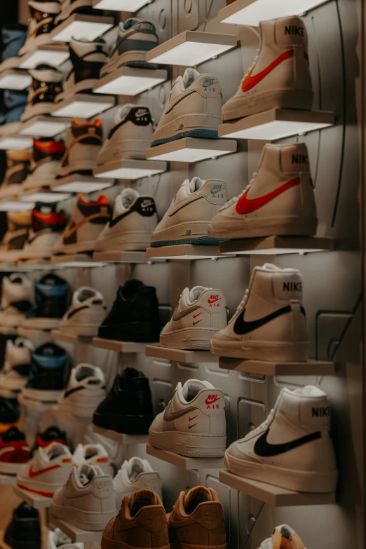 a shelf filled with lots of shoes next to a wall