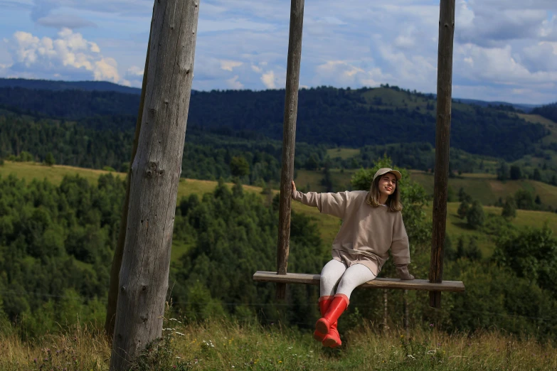 a girl sitting on a swing in the woods