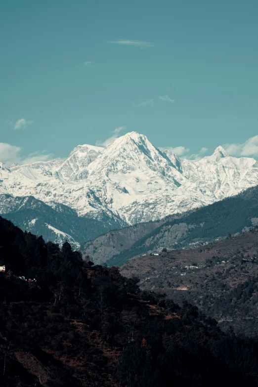 snow - covered mountains in the distance with blue sky