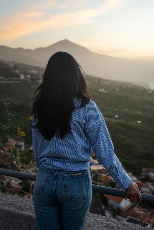 the back of a woman's head while walking on a ledge