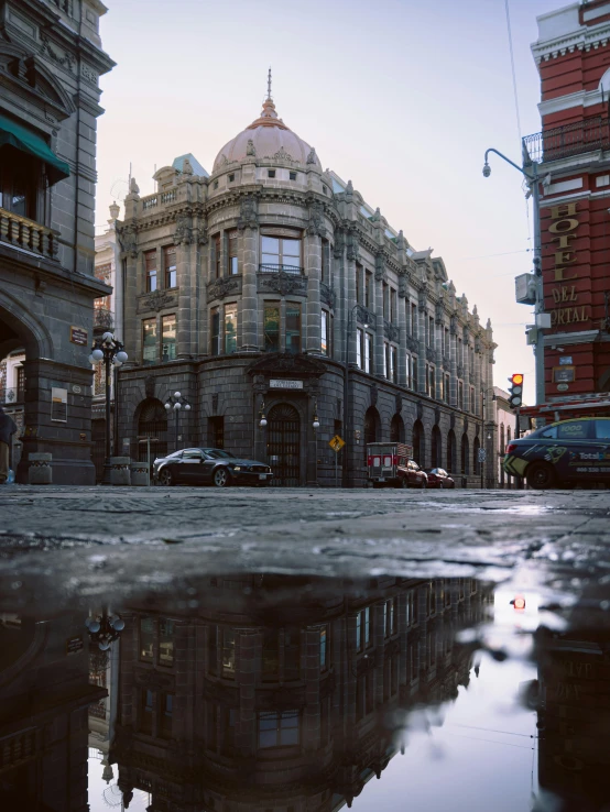 old buildings and tall building reflect in a dle on the wet road