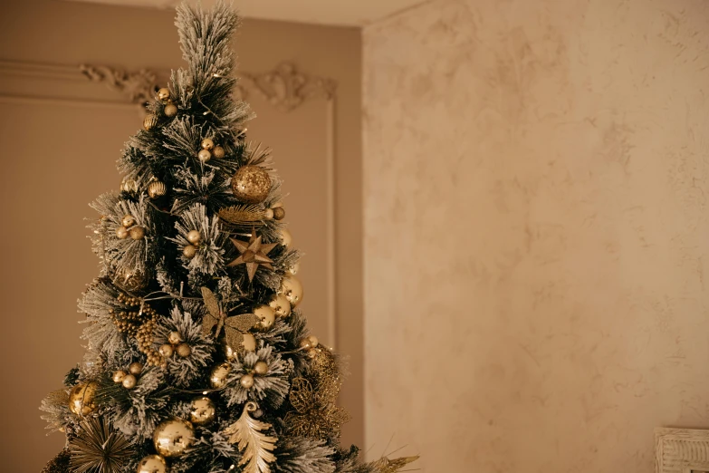 the small christmas tree is decorated in gold and silver