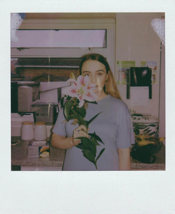 woman holding a flower in her hand near the counter