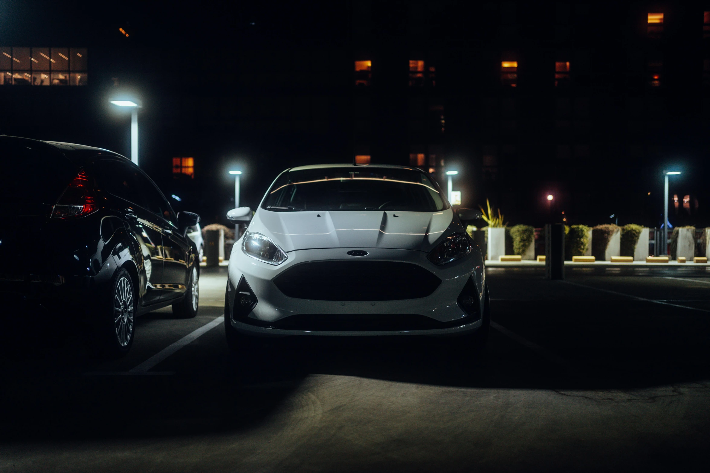 two cars sit parked in a parking lot