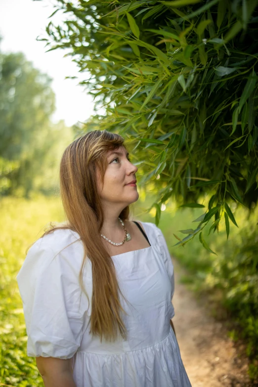 woman standing with arms around large plant outdoors