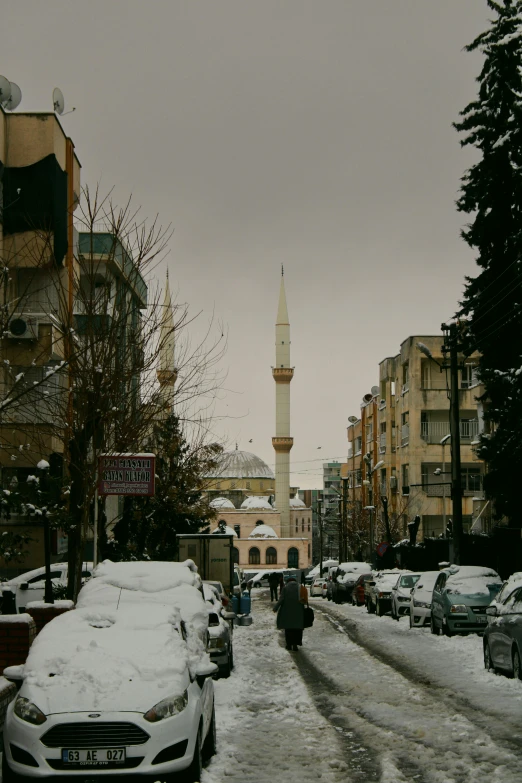 a street with cars and a tower on a cloudy day