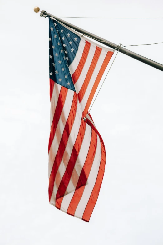 an american flag hangs on a telephone pole