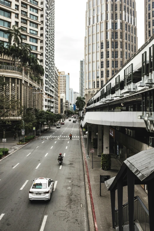 an empty street with a car driving down the road