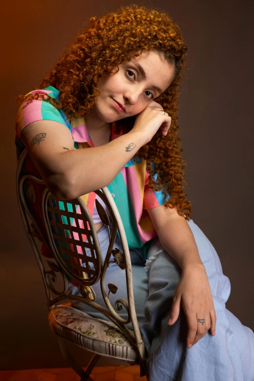 a woman sitting in a chair with a tattooed arm