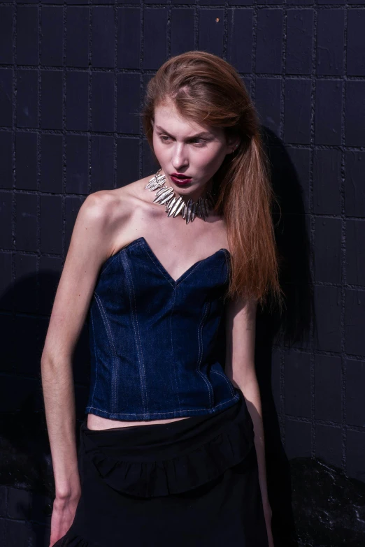 a model with long red hair wearing a blue strapless  top