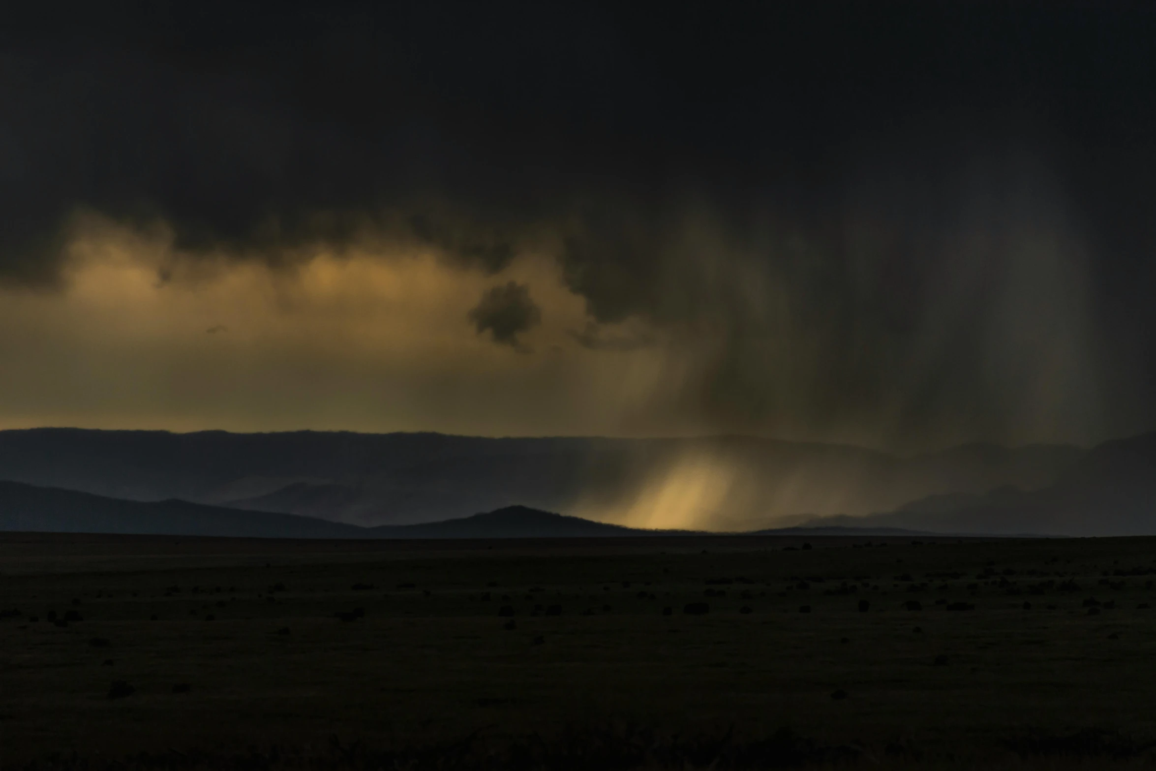 a stormy and cold sky stretches across an empty prairie