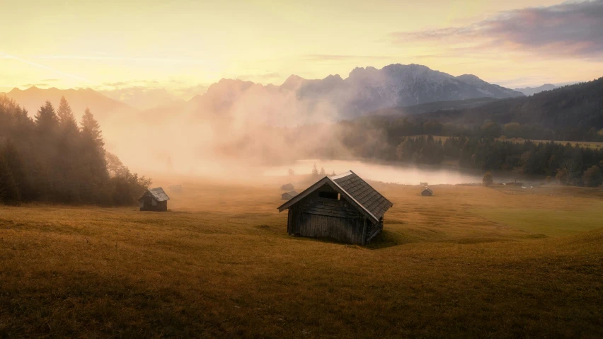 a foggy meadow with a lone house next to it