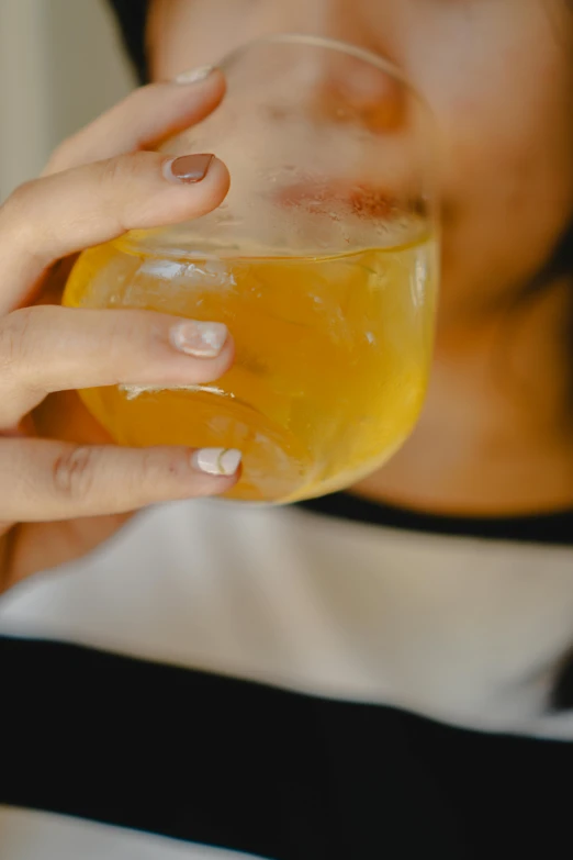 a woman holding a wine glass with soing inside