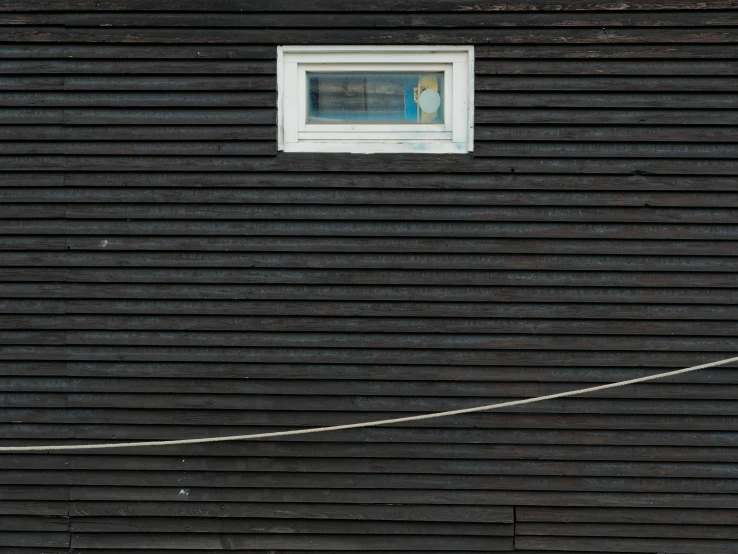 a window that is in the side of a wooden building