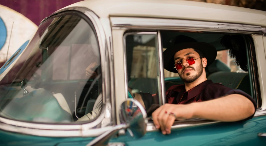 a man with red makeup is driving a car