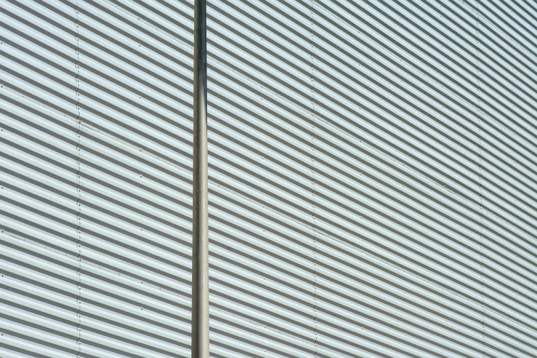 the top part of a light pole near a large building