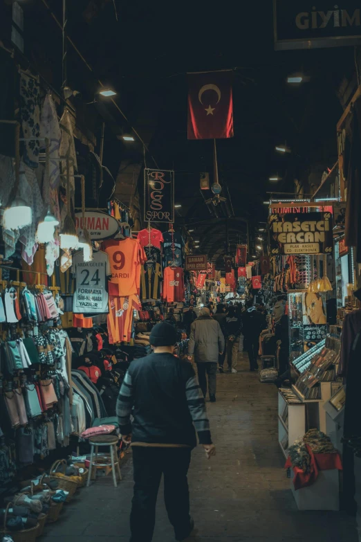 a man is walking through a large and crowded market place