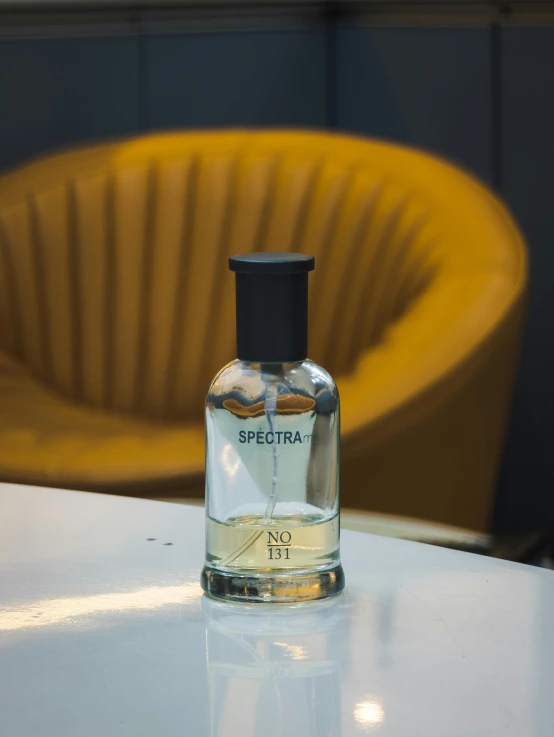 a white table with a glass bottle and a yellow chair in the background