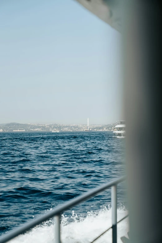 a boat sailing in the ocean, near land