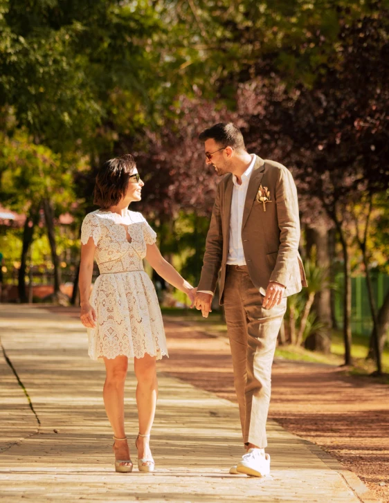 a couple is holding hands on a city sidewalk