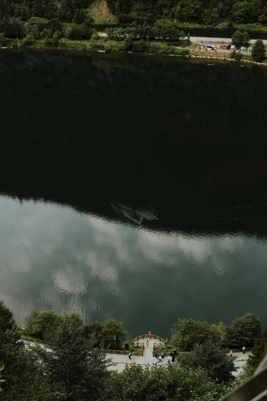 looking down at the lake and houses with clouds above it