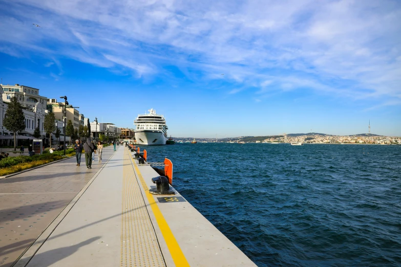 a pier with people standing on the edge and looking at the water