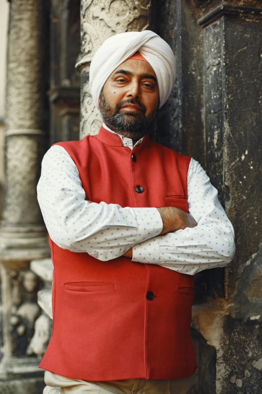 a man with a turban in front of pillars