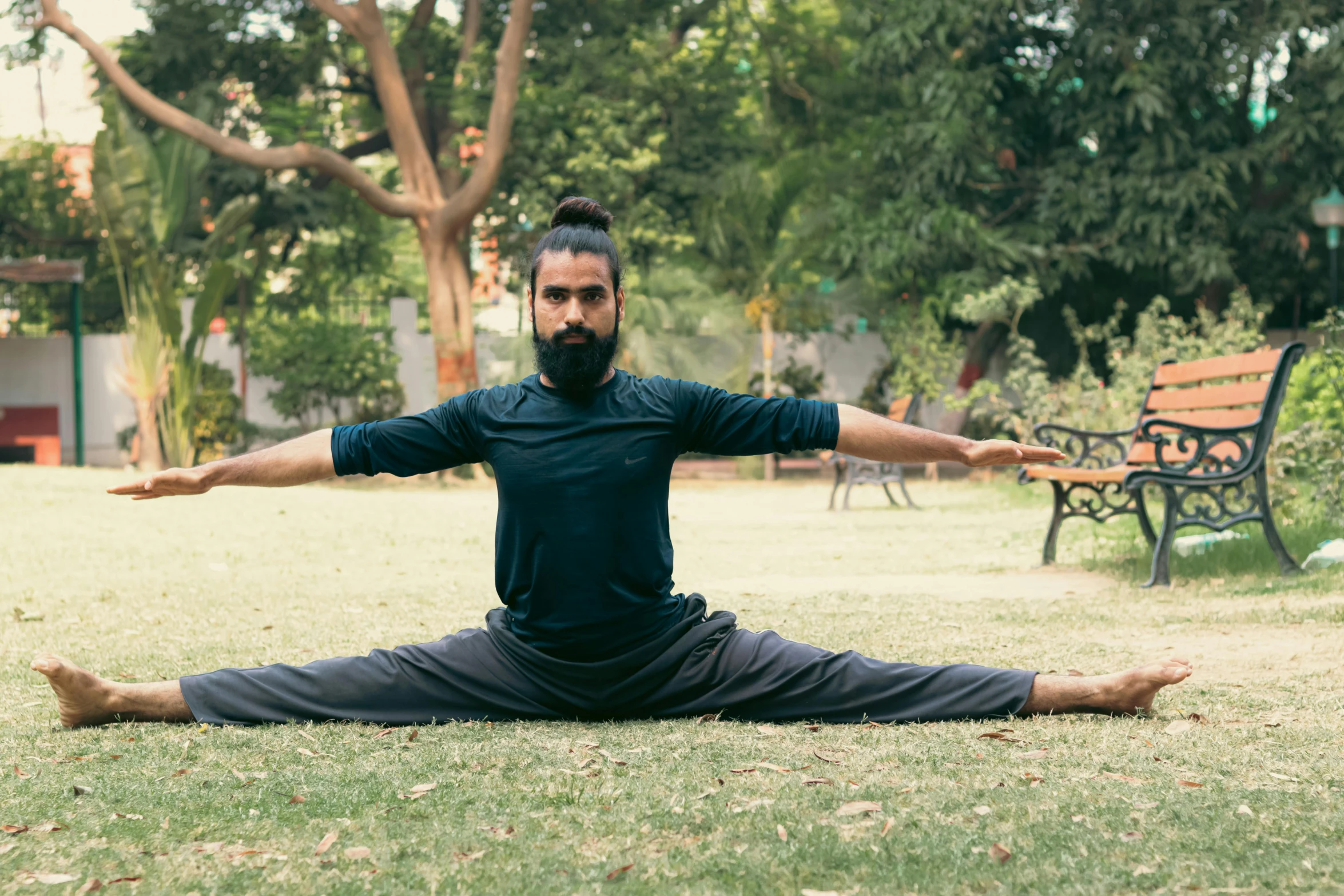 a man who is in the grass doing yoga exercises