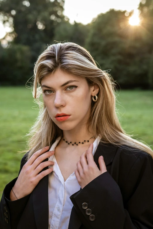 a beautiful woman standing in a field posing for a picture