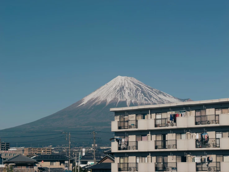 a white and blue building near a large snow capped mountain